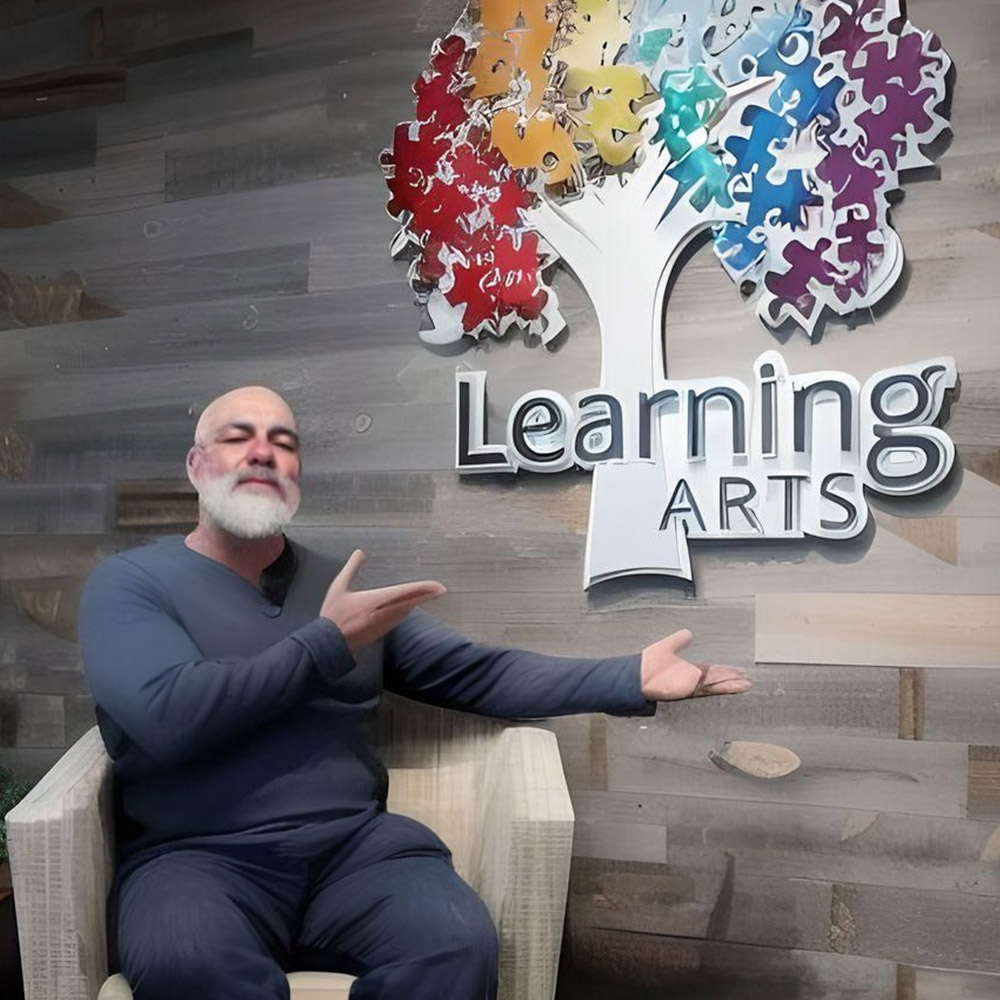 Dr. Will Brandon in front of the Learning Arts Sign